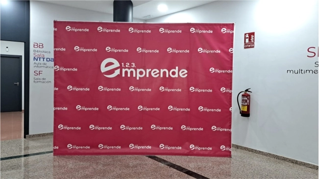 Photocall personalizado de 3x2 metros impreso en lona mediante impresión digital, con imagen corporativa de la empresa 123 Emprende de Jaén.